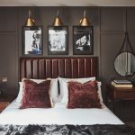 Hotel bed with three vintage posters behind headboard.