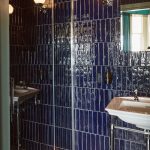 Hotel bathroom with very dark blue tiles